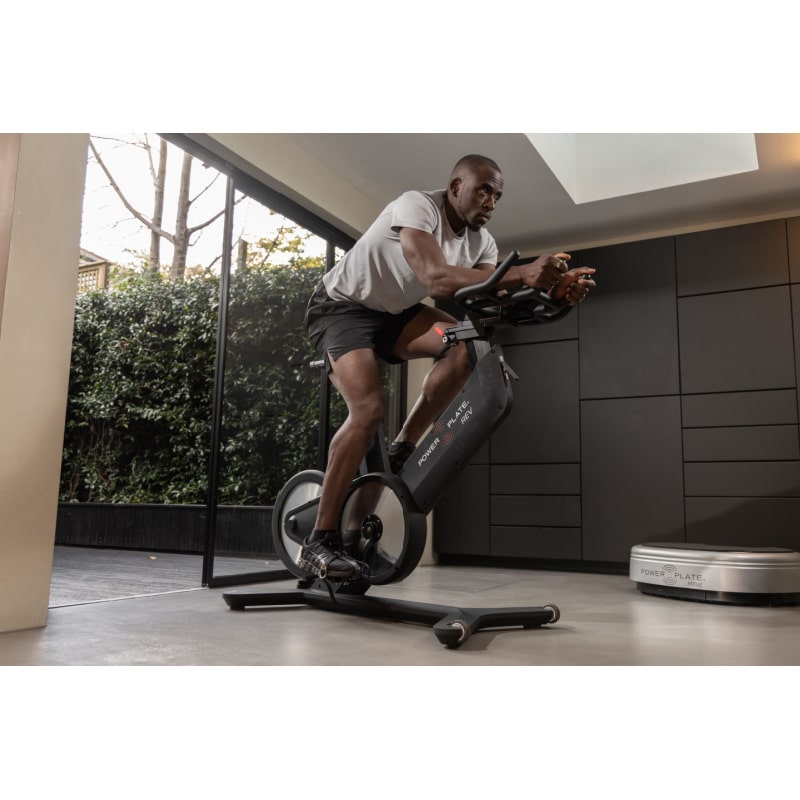 Power Plate REV Lifestyle View Of Bike With Man Exercising