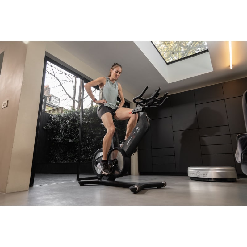 Power Plate REV Lifestyle View Of Bike With Woman On Bike
